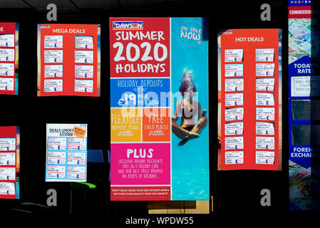 Dans la fenêtre de l'agent de voyage de l'affiche, montrant woman doing yoga sous l'eau, England UK Banque D'Images