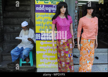 09.11.2015, Yangon, Myanmar, en Asie - un musulman se trouve à côté des mannequins dans un magasin de mode pour dames et lit. Banque D'Images