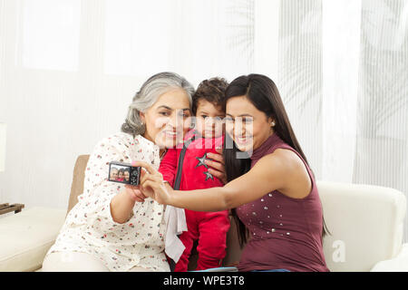 La prise de photo de famille eux-mêmes avec un appareil photo numérique Banque D'Images