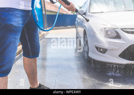 Roue de voiture laver l'homme avec la machine à haute pression pour lavage de voiture Banque D'Images