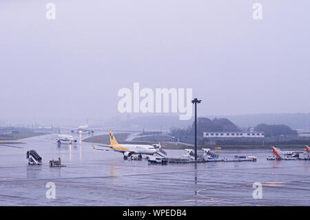 DEC 6, 2018 Narita, Japon - avion pendant le mauvais temps de pluie à l'aéroport international Narita de Tokyo avec le personnel au sol de l'aire de travail à Banque D'Images