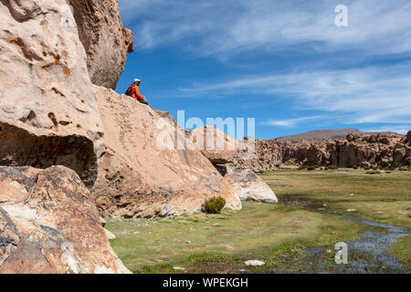 Homme assis sur le rocher au canyon de Black Lagoon, Laguna Negra et paysage rocheux du plateau bolivien, Bolivie, Amérique du Sud Banque D'Images
