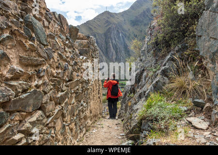 Jeune homme voyageant seul touristique dans la vallée sacrée. Homme Solo hiker with backpack visiter les ruines inca, monument en région de Cuzco, Pérou, Amérique du Sud Banque D'Images