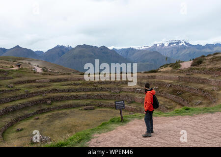 Jeune homme voyageant seul touristique dans la vallée sacrée. Homme Solo hiker with backpack visiter les ruines inca, monument en région de Cuzco, Pérou, Amérique du Sud Banque D'Images