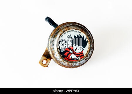 Une vieille et Rusty 'Dennis la menace et Gnasher' (personnages de la bande dessinée pour enfants Beano) bicycle bell, isolé sur fond blanc Banque D'Images