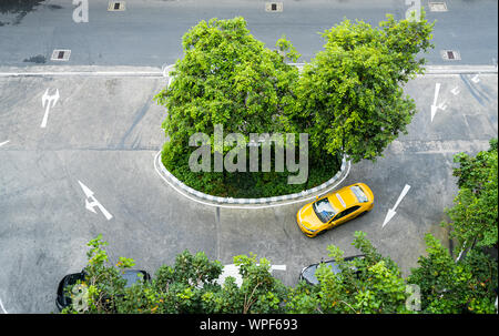 Thaï jaune taxi roulant en centre-ville de Bangkok se démarquer de l'asphalte de gris ci-dessus. Banque D'Images