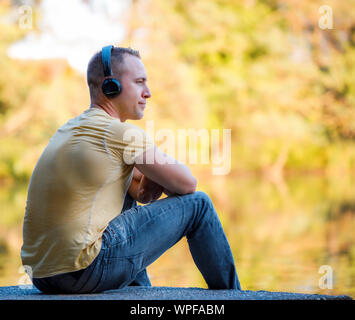 L'homme au casque d'écouter de la musique sur fond d'automne Banque D'Images