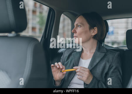 Businesswoman waiting at car siège arrière et jouer avec le crayon pour vaincre l'anxiété Banque D'Images