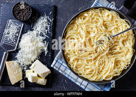 Belrom e pepe, traditionnel plat de pâtes italienne spaghetti mélangée avec du fromage pecorino râpé et saupoudrées de poivre noir fraîchement moulu dans une poêle w Banque D'Images