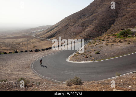 Cycliste homme escalade la route raide à Puerto del Carmen. Lanzarote. Îles Canaries. L'Espagne. Banque D'Images