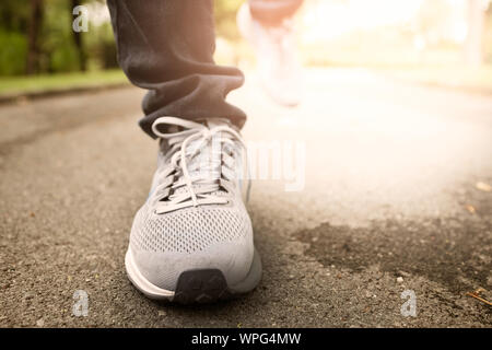 Jogging femme dans Central Park en portant des chaussures de sport de l'exercice dans la soirée coucher du soleil. Banque D'Images