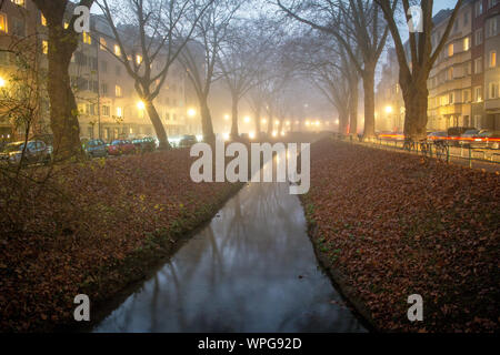 Vue de la rivière dans la saison d'automne sur le brumeux et sombre soir avec des lumières de rue Banque D'Images