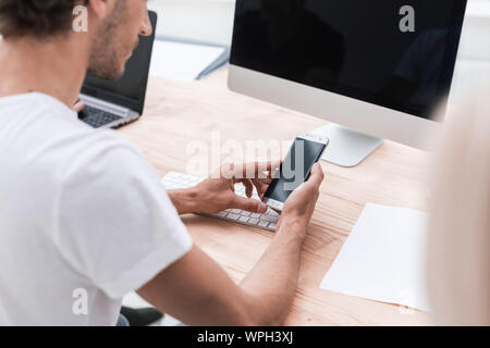 Close up. les jeunes employés à la recherche à l'écran de son smartphone. Banque D'Images