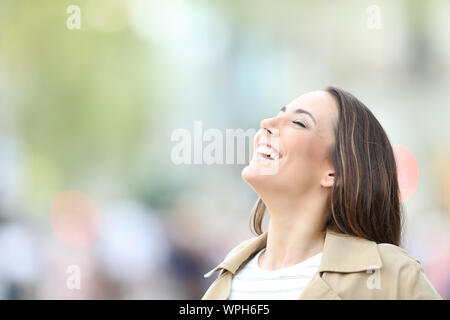 Happy woman, respirant profondément l'air frais dans la rue permanent Banque D'Images