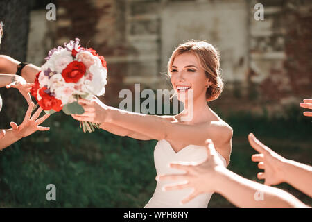 Belle Mariée bouquet de mariage jette à ses amis Banque D'Images