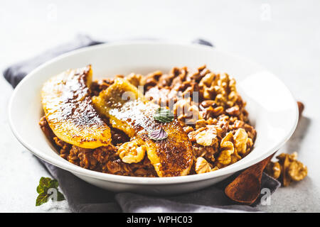 Avec l'avoine au chocolat banane poêlée et noyer dans une assiette blanche. Banque D'Images