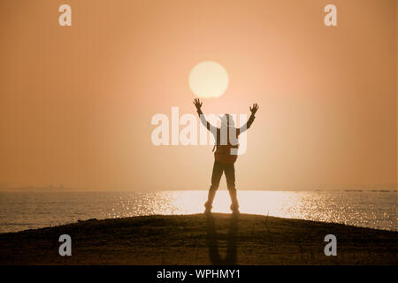 Homme debout et main ouverte sur fond coucher et au lever du soleil Banque D'Images