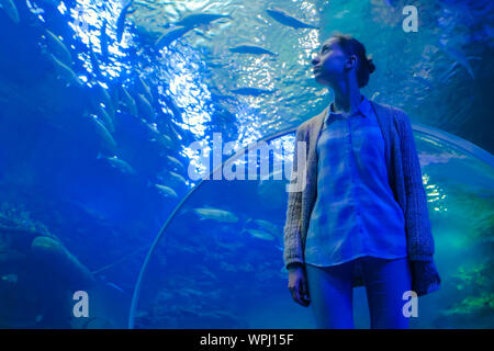 Femme à la recherche du poisson à vortex dans grand public aquarium réservoir à l'Oceanarium Banque D'Images