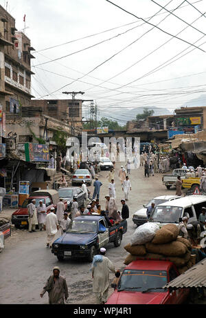 Scène de rue à Landikotal au Pakistan avec des personnes, des véhicules et des marchandises pour la vente. Landikotal est sur le col de Khyber et est près de Peshawar, Pakistan. Banque D'Images