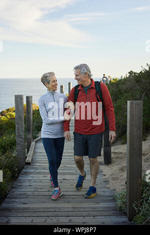 Toute la longueur du couple waling sur boardwalk against sky Banque D'Images