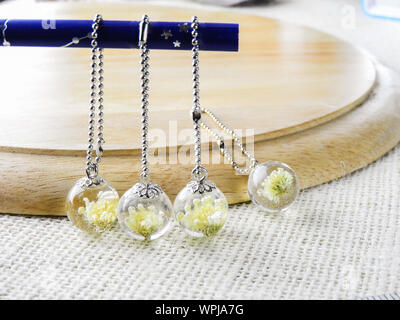 Les fleurs séchées en résine crystal clear, pendentif pendentif avec un vrai fleurs. Banque D'Images