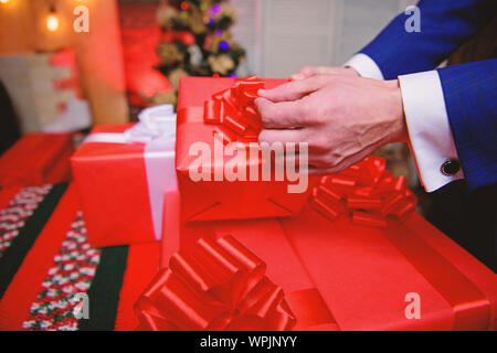 Cadeaux concept. Moments magiques. Préparer des cadeaux surprises pour la famille et les amis. Boîtes cadeaux avec big ribbon bow close up. Les cadeaux emballés rouge ou présente. Se préparer à Noël et nouvel an. Banque D'Images