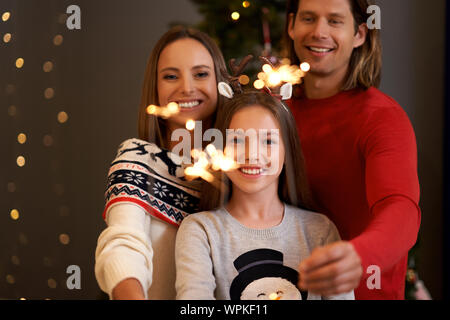 Belle famille fêter Noël et holding sparklers Banque D'Images