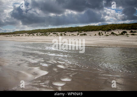 Une promenade le long de la plage dans un temps orageux avec une marée haute en été à Ameland Banque D'Images
