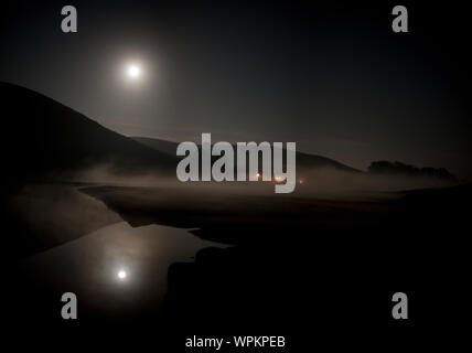 Pleine lune qui brille au-dessus d'un paysage rural de Misty. Banque D'Images