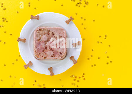 Joyeux anniversaire gâteau pour chien à partir de la nourriture humide et le traite sur jaune with copy space Banque D'Images