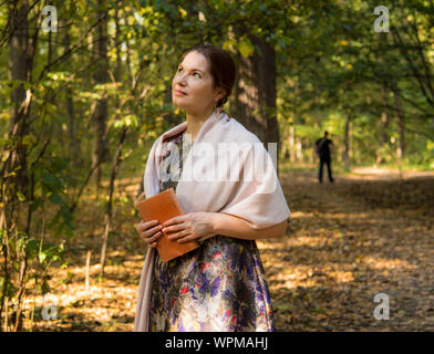 Une belle femme d'âge moyen se tient sur un chemin dans le parc Banque D'Images