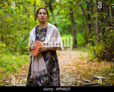 Une belle femme d'âge moyen se tient sur un chemin dans le parc Banque D'Images