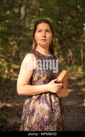 Une belle femme d'âge moyen se tient sur un chemin dans le parc Banque D'Images