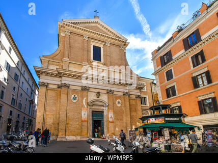 Les touristes passent par un petit papier de nouvelles se tiennent à l'extérieur du Sant'Andrea delle Fratte église dans le centre historique de Rome, Italie. Banque D'Images