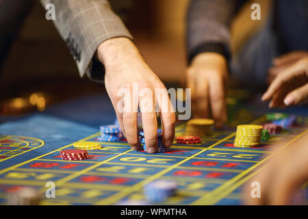 Jetons dans les mains d'un joueur dans un casino. Banque D'Images