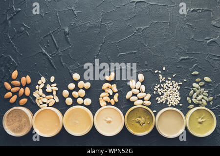 Le beurre de noix et graines en pots avec des ingrédients. Des matières organiques, d'arachides, amandes, pistaches, noix de cajou hazlenut, noix de macadamia et de tournesol, une pâte Banque D'Images