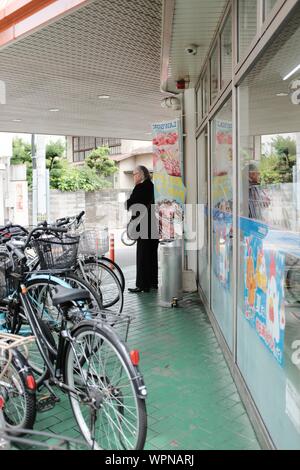 MATSUYAMA, JAPON - 20 juil 2019 : une ligne verticale d'un homme debout à un marché près de bicyclettes à l'extérieur Banque D'Images