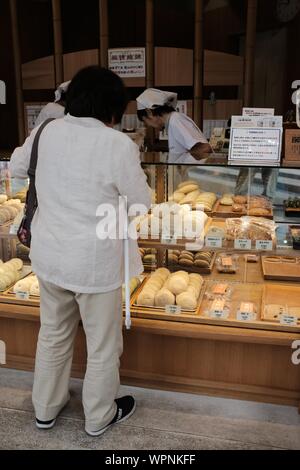 MATSUYAMA, JAPON - 20 juil 2019 : une ligne verticale à l'intérieur de femmes d'une boulangerie en face d'un décrochage Banque D'Images