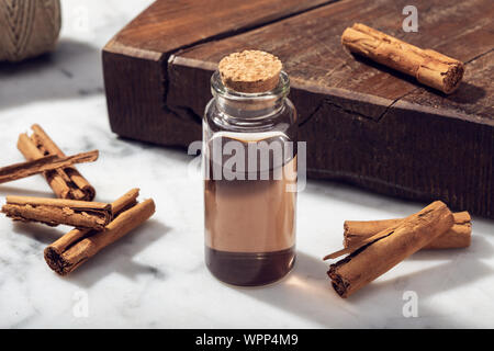 L'huile essentielle de cannelle sur table de marbre. L'huile de cannelle pour les cosmétiques ou soins de beauté Banque D'Images