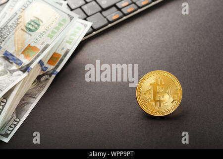 Gros plan sur Bitcoin or billet de dollar sur ordinateur sur fond noir. Banque D'Images