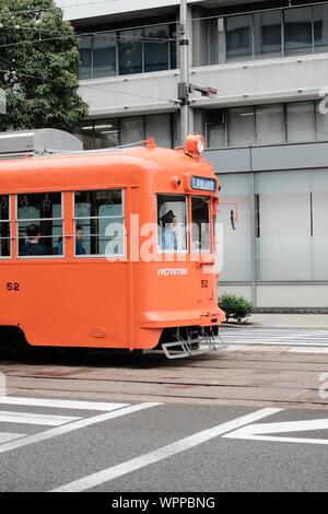 MATSUYAMA, JAPON - 20 juil 2019 : un plan vertical d'une orange sur un train en marche de la rue Banque D'Images