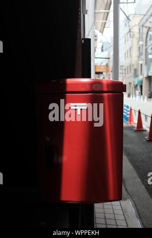 MATSUYAMA, JAPON - 20 juil 2019 : un gros plan vertical shot d'un pendu de corbeille rouge sur une surface brune Banque D'Images