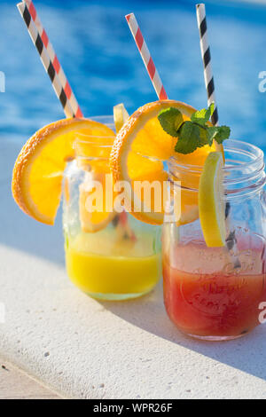 Lunettes avec de savoureux cocktails proche piscine Banque D'Images