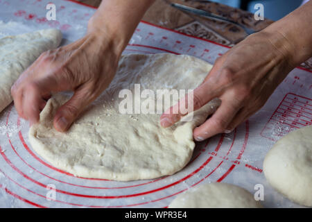 Close up of a woman's hands faire la pâte pour le pain maison, des empanadas. female baker la préparation de pain sur une plaque à pâtisserie en silicone Banque D'Images