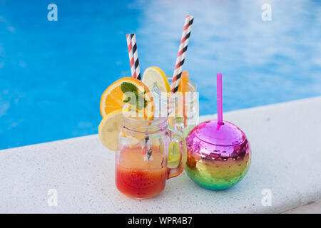 Lunettes avec de savoureux cocktails proche piscine Banque D'Images