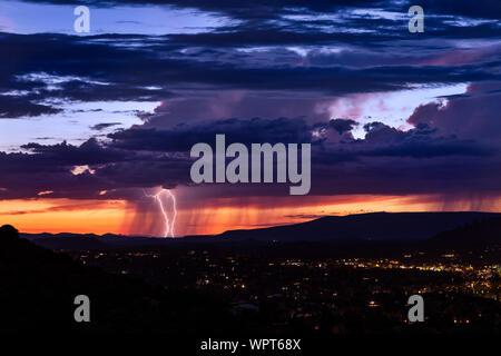 Sedona, Arizona coucher de soleil avec la foudre d'une tempête lointaine Banque D'Images