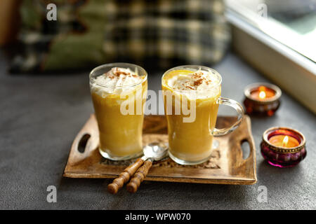 Une composition d'automne citrouille de latte dans deux tasses en verre sur le rebord Banque D'Images