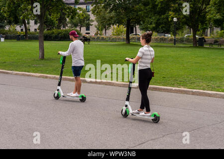 Montréal, CA - 7 septembre 2019 : deux personnes équitation un scooter électrique Lime Banque D'Images