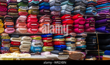 Rouleaux de tissus et textiles dans un magasin. beaucoup de couleurs et de motifs Banque D'Images