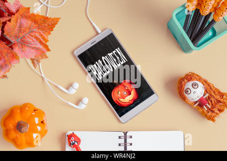 Happy Halloween laïcs Télévision Téléphone Mobile fond maquette concept. Vue de dessus de bureau sur smartphone 24 Table avec accessoires d'Halloween. Desi laïcs Télévision Banque D'Images